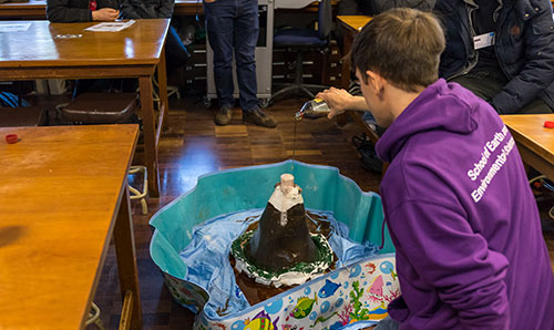 A secondary school student conducting a model volcano experiment at the University